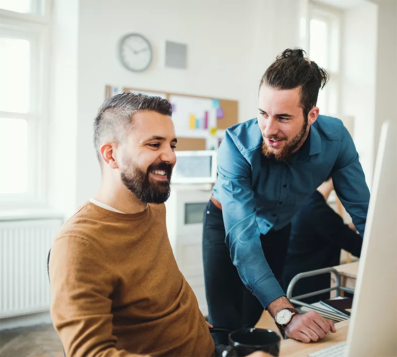 Twee collega’s overleggen samen achter een beeldscherm